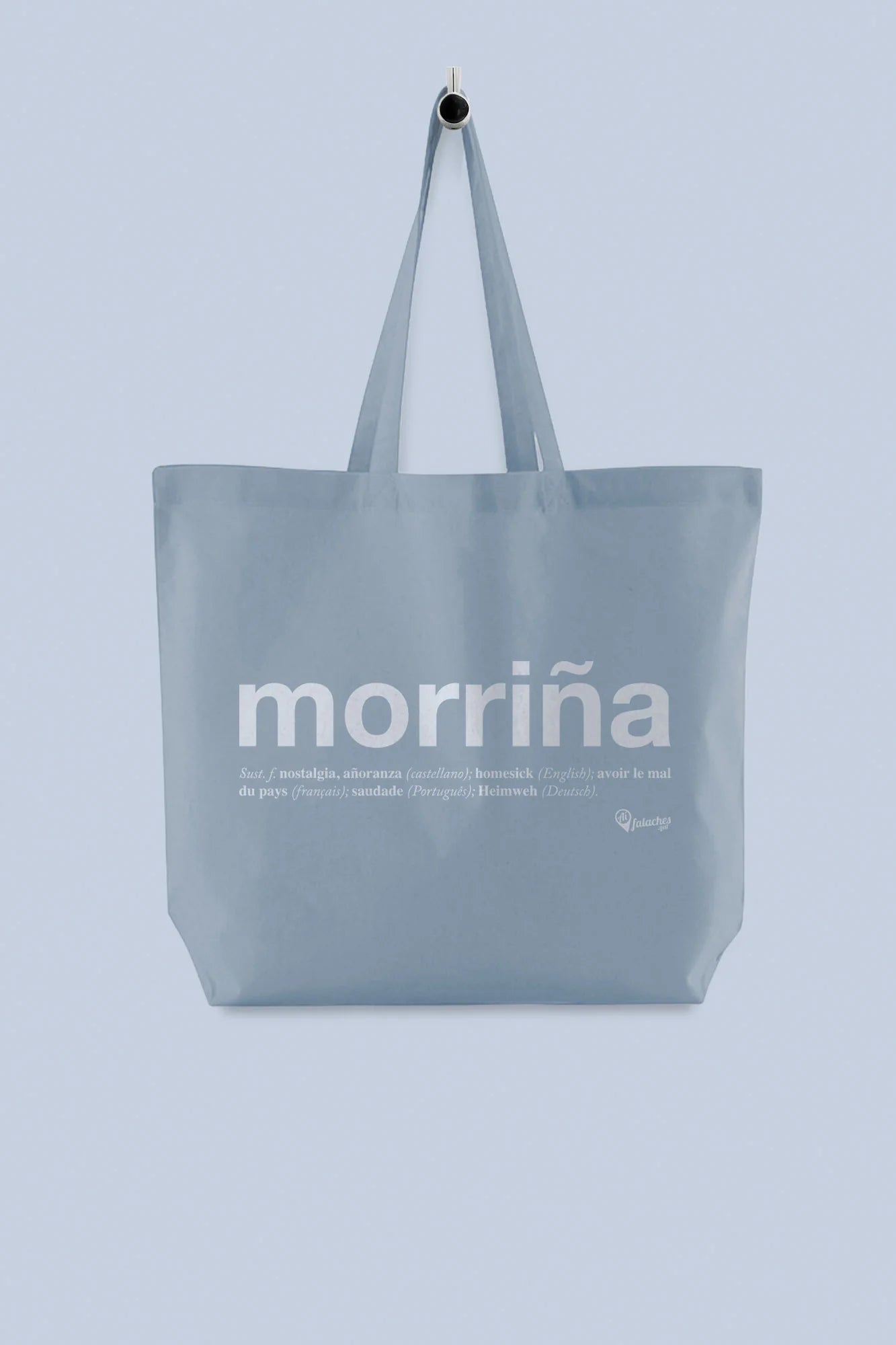 Tote bag grande de tea gris azulado coa palabra "morriña" impresa, colgada dun percheiro